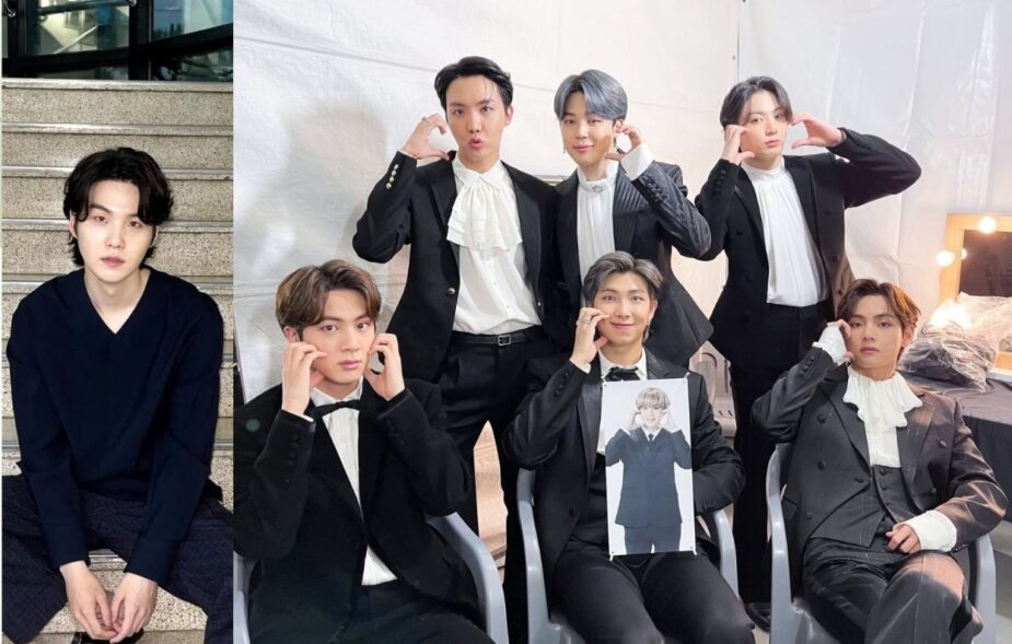 Six of BTS’s members carrying a photo of Suga